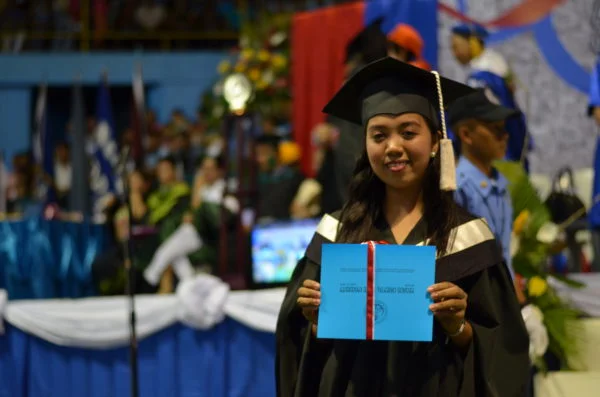 HELPS - A student of our education program holds up her graduation certificate.