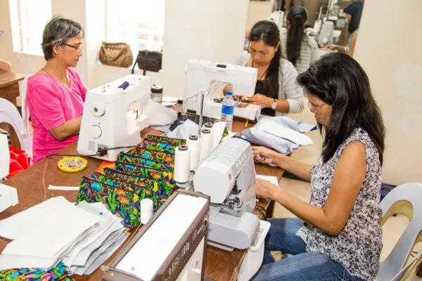 Mothers are pictured sewing small bags as part of our livelihood program.